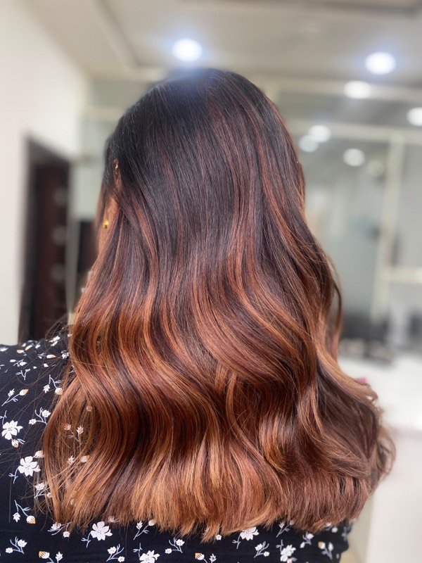 Copper balayage blended through long, soft waves