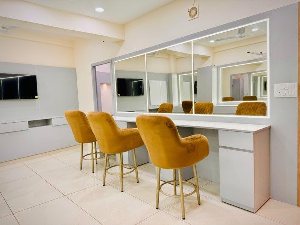 Makeup studio with vanity mirrors and velvet chairs